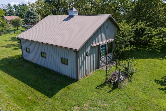 view of side of property featuring metal roof, fence, a lawn, board and batten siding, and a chimney