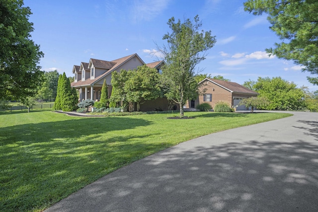 view of front of home with a garage, fence, and a front lawn