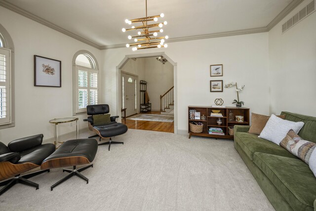 sitting room with light wood-type flooring, crown molding, and a notable chandelier