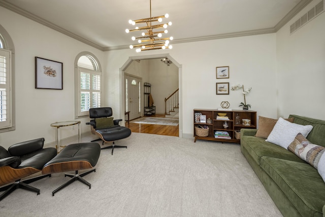 living area featuring arched walkways, ornamental molding, stairs, and visible vents