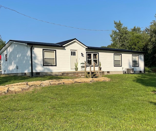 back of house with central AC and a lawn