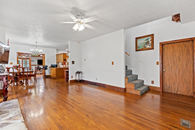 living room with a textured ceiling, hardwood / wood-style flooring, and ceiling fan with notable chandelier