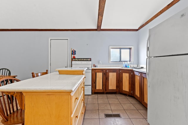 kitchen featuring white appliances, light tile patterned floors, tile counters, a kitchen island, and sink