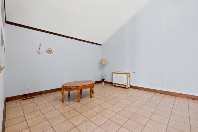 living area with lofted ceiling and light tile patterned floors