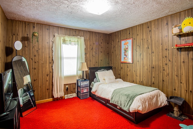 carpeted bedroom featuring wooden walls and a textured ceiling