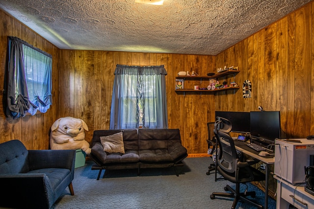 carpeted office space with wood walls and a textured ceiling