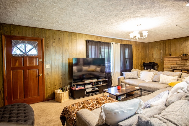 living room featuring carpet flooring, a textured ceiling, wooden walls, and a chandelier