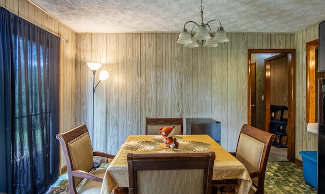 dining space with wood walls and a chandelier