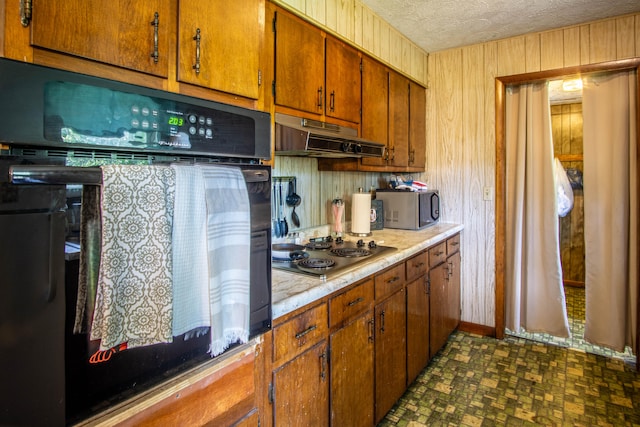 kitchen featuring electric cooktop, dark tile patterned floors, a textured ceiling, and oven