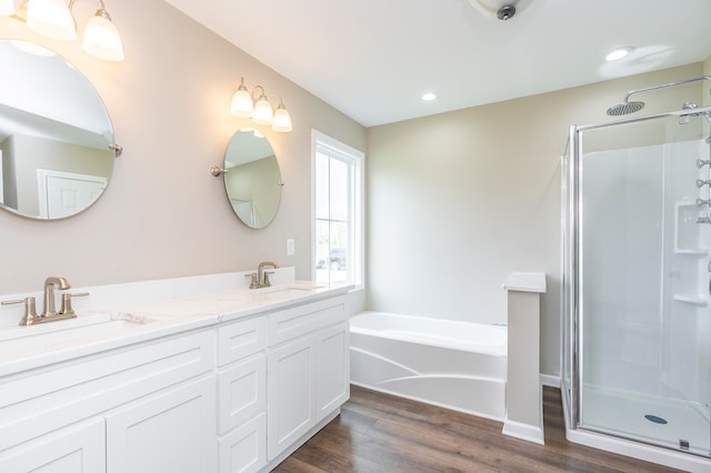 bathroom featuring shower with separate bathtub, dual bowl vanity, and hardwood / wood-style floors