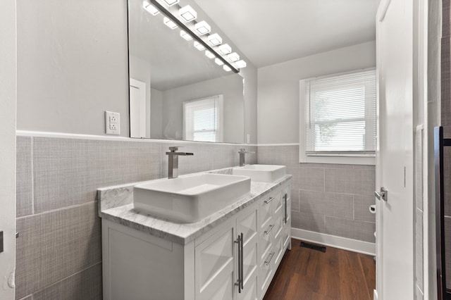 bathroom featuring tile walls, hardwood / wood-style flooring, vanity, and a wealth of natural light