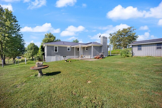 rear view of property featuring a patio area and a yard