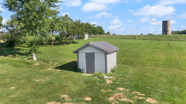 view of outdoor structure featuring a rural view and a lawn