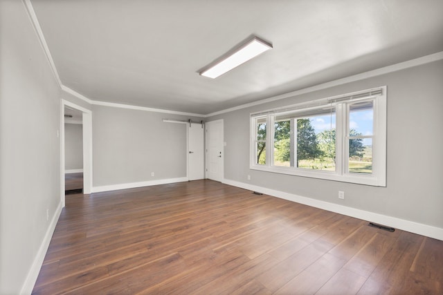 empty room featuring hardwood / wood-style flooring and crown molding