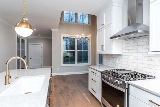 kitchen with crown molding, light hardwood / wood-style flooring, sink, wall chimney range hood, and gas range oven