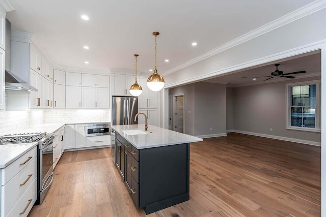 kitchen featuring light wood-type flooring, stainless steel appliances, crown molding, and light stone countertops