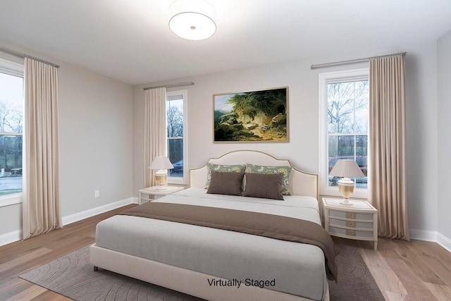 bedroom with light hardwood / wood-style flooring and multiple windows