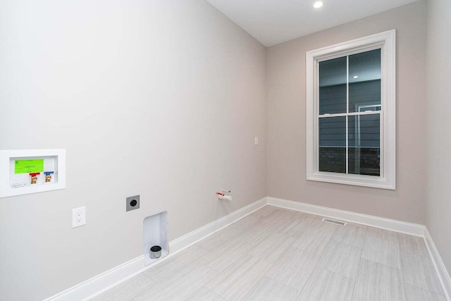 laundry area with electric dryer hookup, hookup for a washing machine, and light tile patterned floors