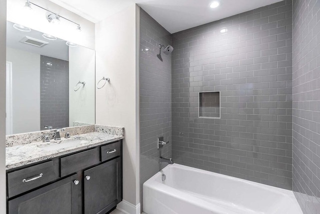 bathroom with vanity and tiled shower / bath combo