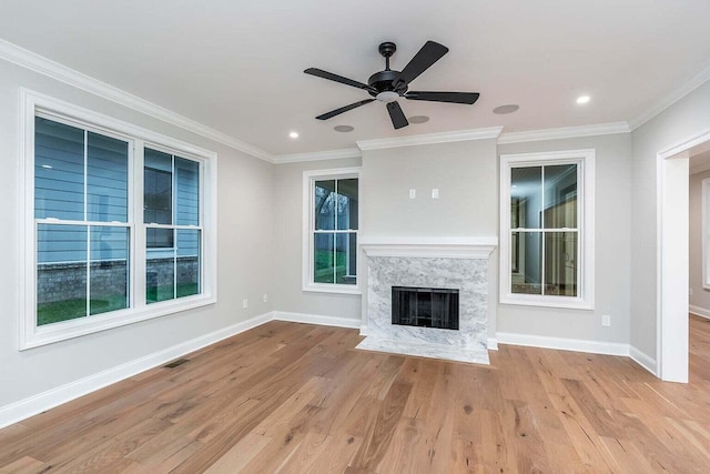 unfurnished living room with ceiling fan, light wood-type flooring, and a high end fireplace