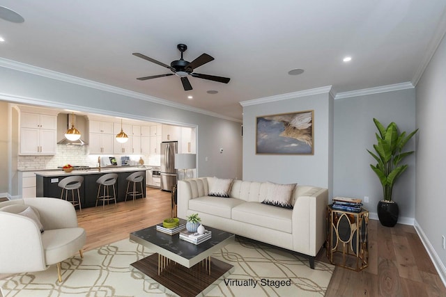 living room featuring ceiling fan, light wood-type flooring, and ornamental molding