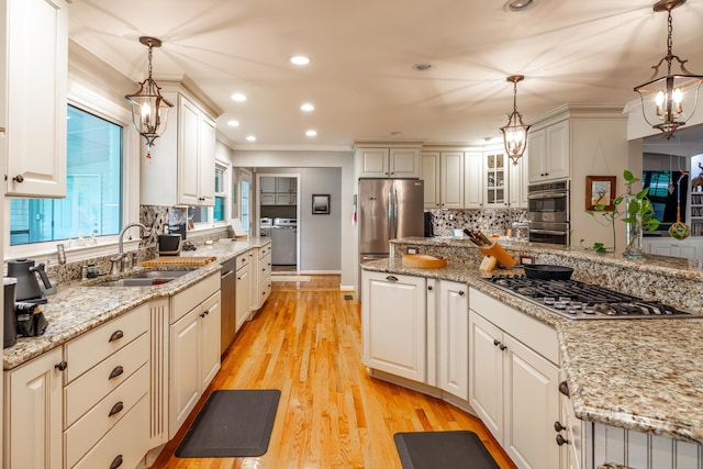 kitchen featuring stainless steel appliances, sink, and decorative light fixtures