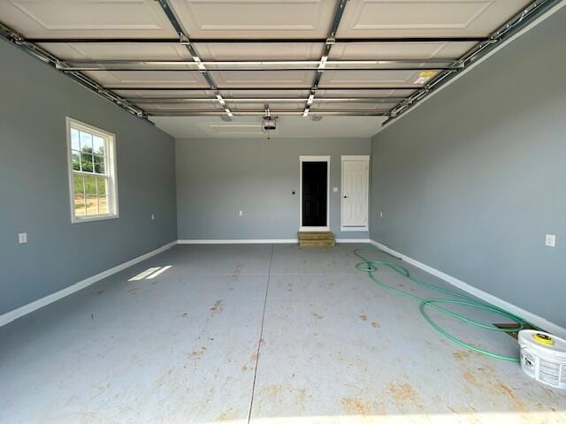 garage featuring a garage door opener and baseboards