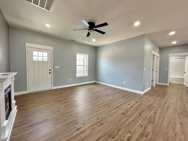 unfurnished living room featuring ceiling fan and wood-type flooring