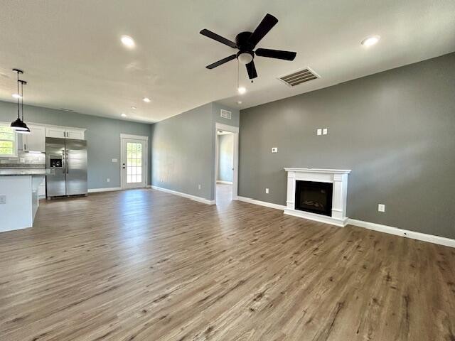 unfurnished living room featuring light wood-type flooring and ceiling fan