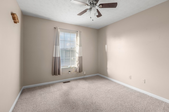 carpeted empty room featuring ceiling fan and a textured ceiling