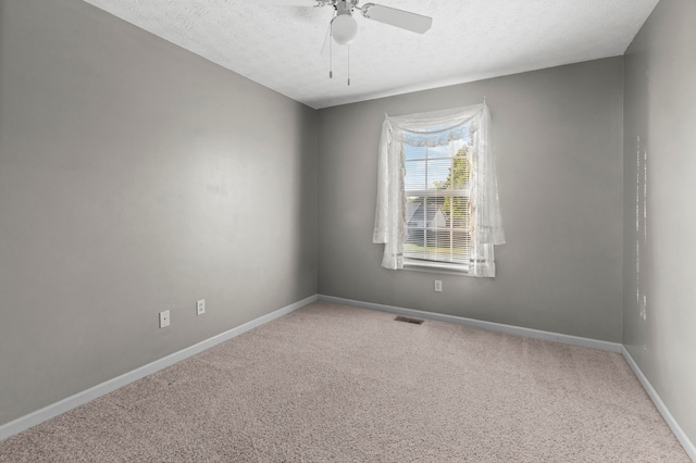 spare room with a textured ceiling, ceiling fan, and carpet floors