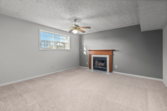 unfurnished living room with ceiling fan, a textured ceiling, and carpet floors