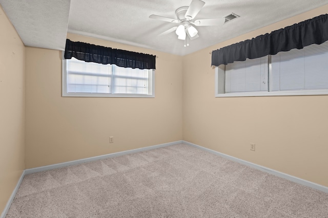 spare room with a textured ceiling, carpet flooring, and ceiling fan