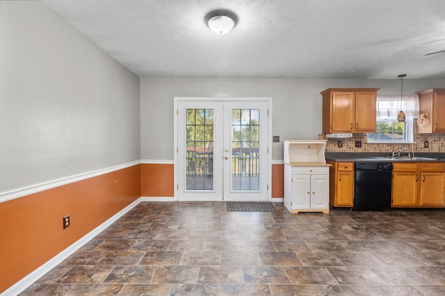 kitchen featuring dark tile patterned flooring, pendant lighting, a healthy amount of sunlight, and dishwasher