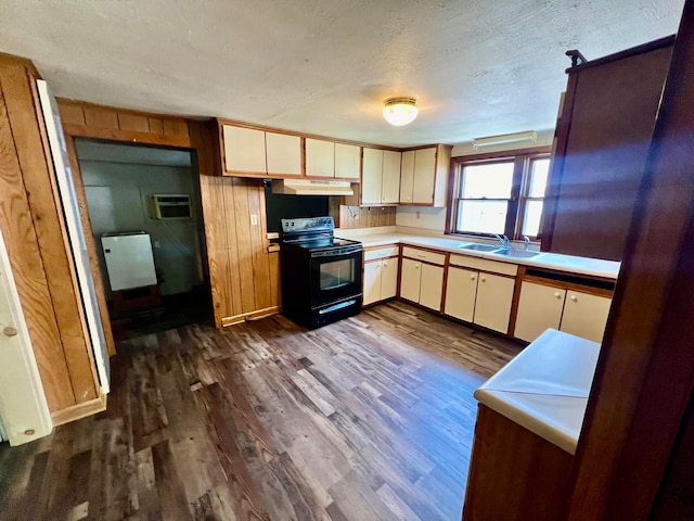 kitchen with a textured ceiling, dark hardwood / wood-style flooring, cream cabinetry, black range with electric cooktop, and sink