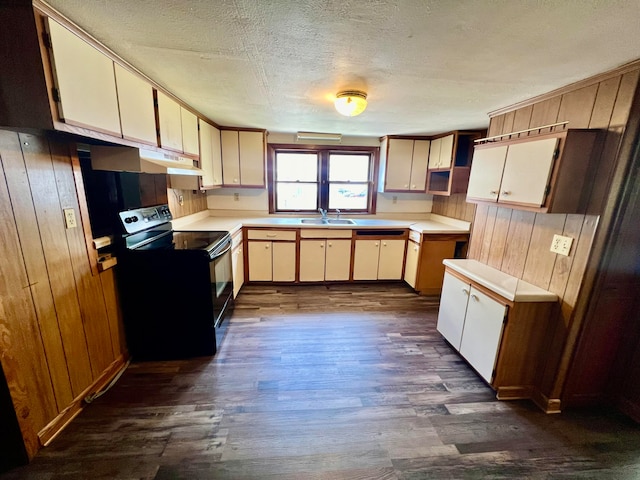 kitchen featuring a textured ceiling, dark hardwood / wood-style flooring, cream cabinetry, sink, and black electric range