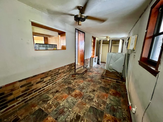 empty room with dark tile patterned flooring, ceiling fan, and cooling unit