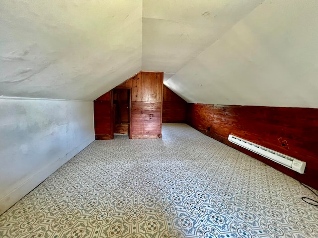 bonus room featuring a baseboard heating unit, light tile patterned floors, vaulted ceiling, and a textured ceiling