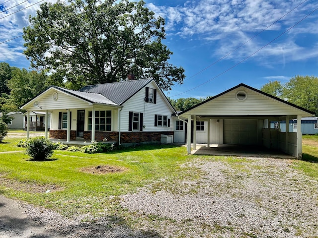 view of front of house with a carport, covered porch, a front yard, and a garage