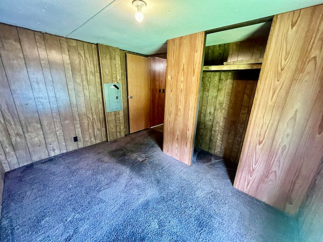 unfurnished bedroom with wood walls and dark carpet