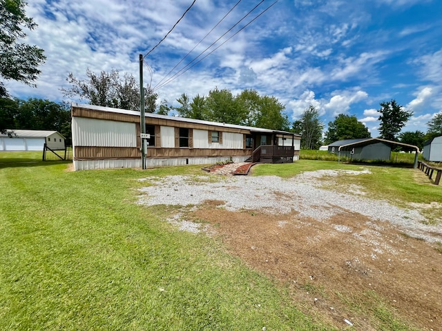 view of front facade with a wooden deck, a front yard, and an outdoor structure