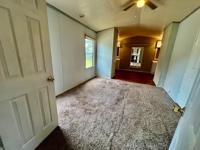 unfurnished bedroom featuring ceiling fan, carpet flooring, a textured ceiling, and lofted ceiling