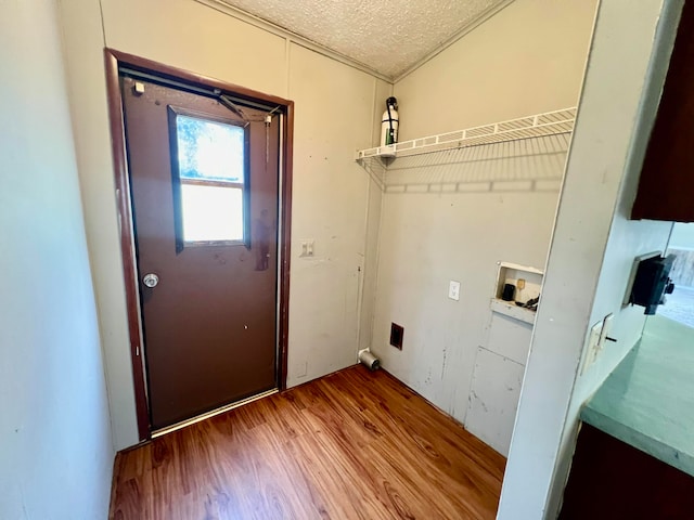 laundry area featuring hookup for a washing machine, a textured ceiling, and hardwood / wood-style floors