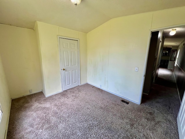 unfurnished bedroom with lofted ceiling and carpet floors