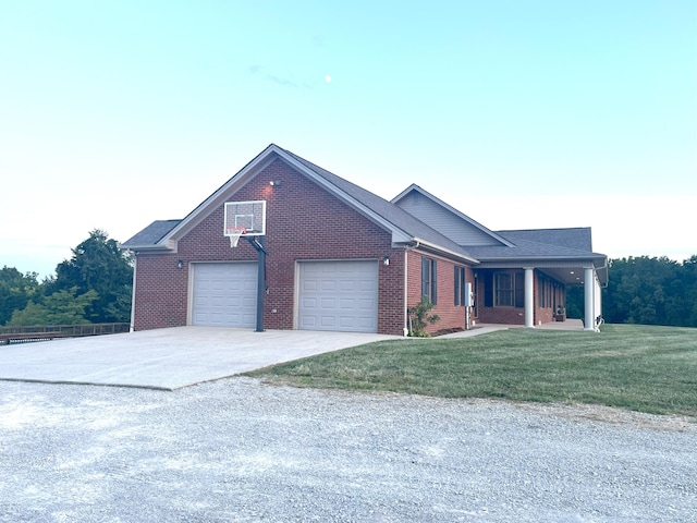 view of front of house with a garage, a front yard, brick siding, and driveway