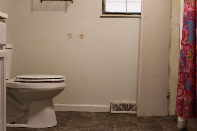 bathroom featuring toilet and tile patterned flooring