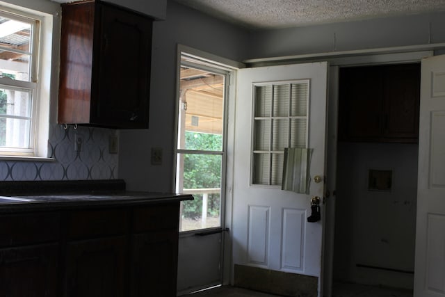 kitchen featuring decorative backsplash, plenty of natural light, and a textured ceiling