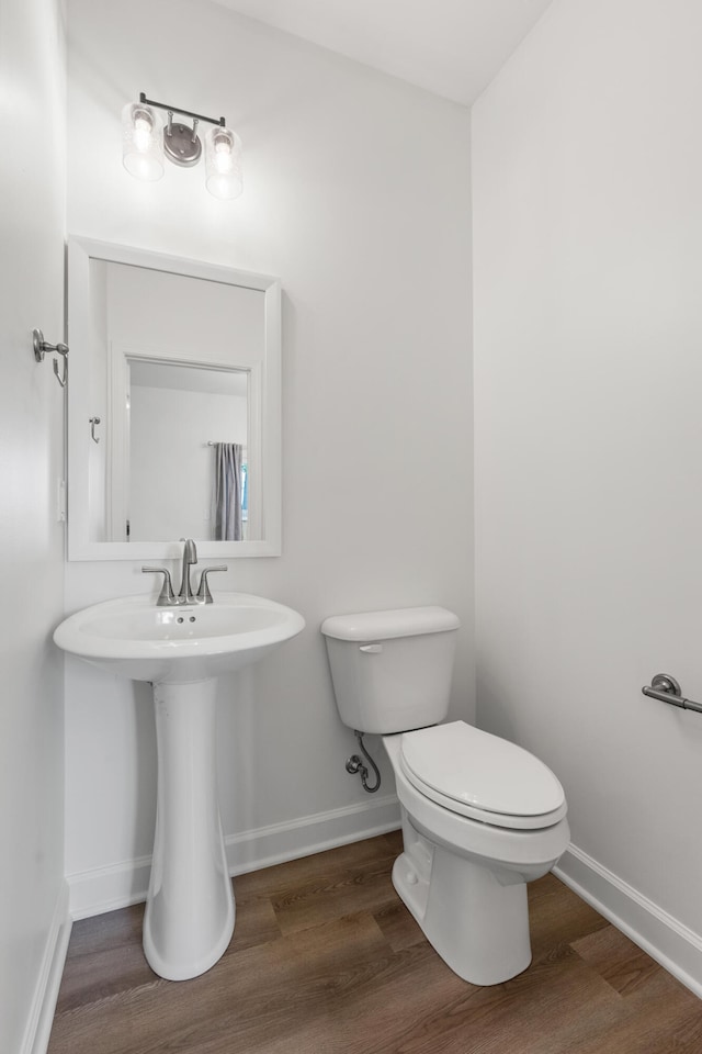 bathroom featuring hardwood / wood-style floors and toilet