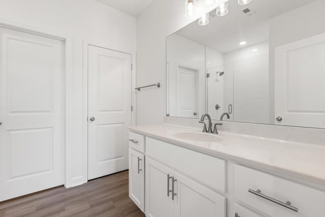 bathroom with vanity, wood-type flooring, and walk in shower