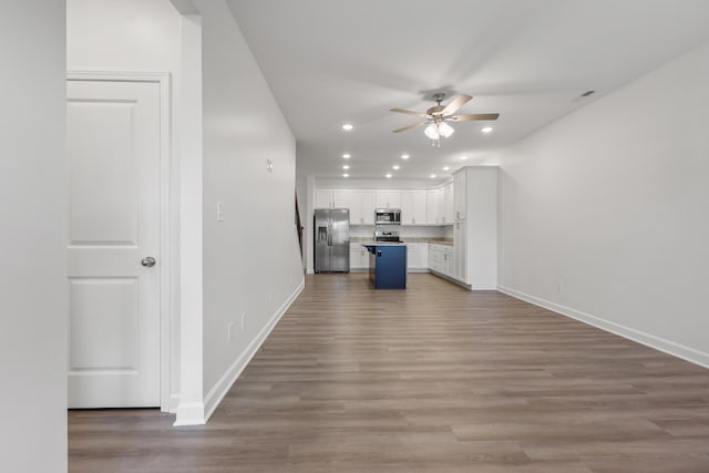 kitchen featuring light hardwood / wood-style floors, a kitchen island, white cabinetry, and appliances with stainless steel finishes